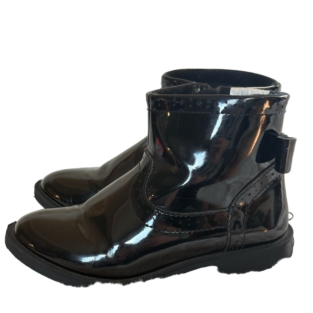 Little girls glossy black boots with bow on the back.